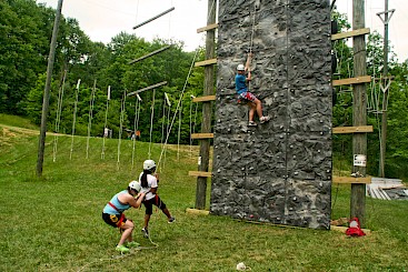 Staff demonstrating climbing wall saftey